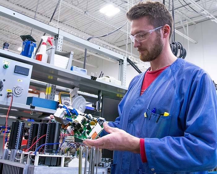 A KEB Service and Repair technician inspecting a VFD circuit board